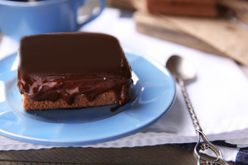 Delicious chocolate brownie on plate on wooden background