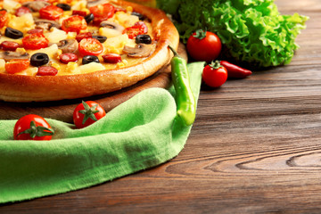 Delicious pizza with vegetables and meat on green napkin, close-up