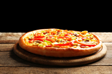 Delicious pizza with vegetables on black background
