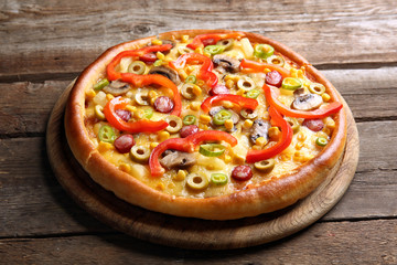 Delicious pizza on wooden background