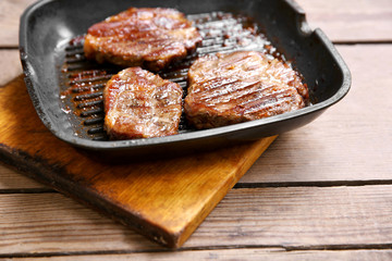 Roasted beef fillet on pan, on wooden background