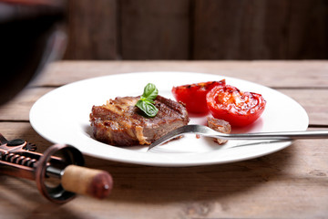 Roasted beef fillet on plate, on wooden background
