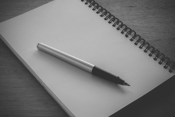 paper notebook and pen on a table with filter effect retro vinta