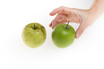 Closeup on hand choosing between two green apple isolated