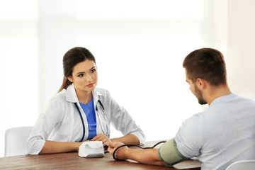 Female doctor examining patient blood pressure