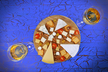 Cheese for tasting on blue wooden background, top view