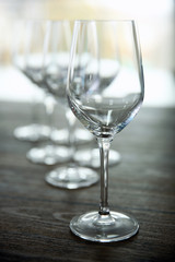 Empty wine glasses on wooden table against blurred background