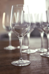 Empty wine glasses on wooden table against blurred background