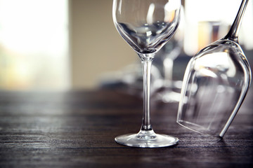 Empty wine glasses on wooden table against blurred background