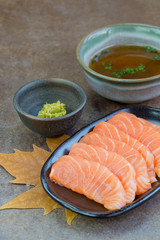 Sliced raw salmon on black plate with  background