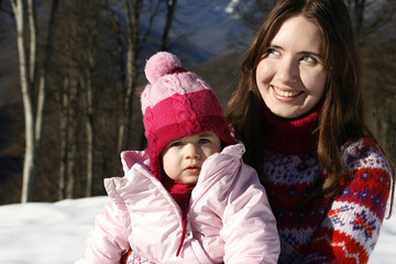 Fototapeta premium Mother and daughter playing in the snow