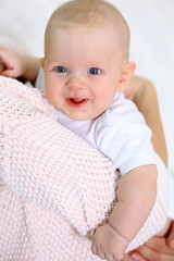 Woman holds adorable baby in hands, close up