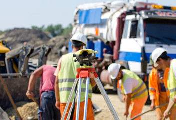 Theodolite and workers at construction site