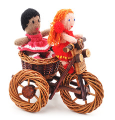 Tied dolls on toy bike.