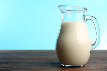 Jar of milk on table on blue background