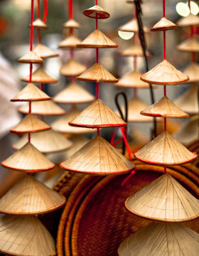 Close up of little Vietnamese hats for sale cascading on strings in Hanoi, Vietnam