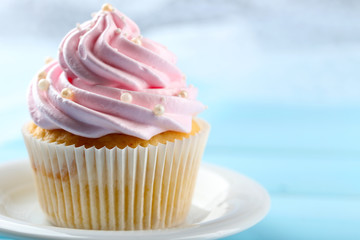 Pink cupcake on wooden background