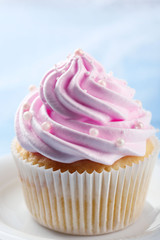 Pink cupcake on wooden background