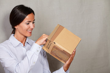 Toothy smile woman standing and opening parcel