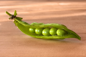 green pea pod on the wooden table