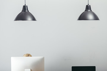 workplace interior with computers and two black lamps