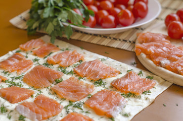 Slices of salmon with cutted dill on a piece of pita. Cooking
