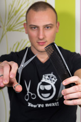 Hair stylist holding in hand scissors and hairdresser equipment wearing t-shirt with title 