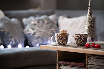 Winter scene. Living room, mugs, candle on the table.