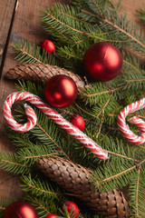 Christmas tree branch, candy, cones, balls on the background of