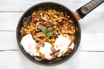 Eggs Benedict with vegetable ragout: mushrooms, corn, basil, red