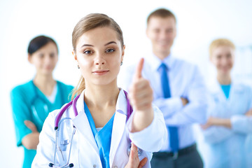 Young happy female doctor showing thumbs up