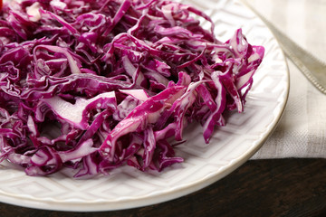 Red cabbage salad served on plate closeup