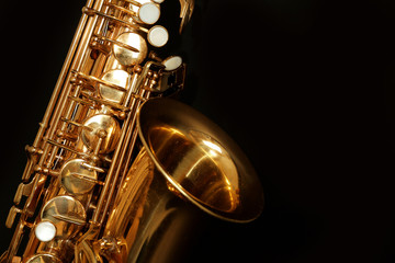 Beautiful golden saxophone on black background, close up - obrazy, fototapety, plakaty