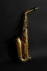 Obraz premium Beautiful golden saxophone on black background