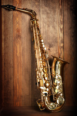 Fototapeta na wymiar Beautiful golden saxophone on wooden background
