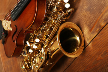 Obraz premium Close up view on musical instruments: saxophone, violin in wooden box