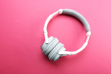 Wireless white and grey headphones on pink background