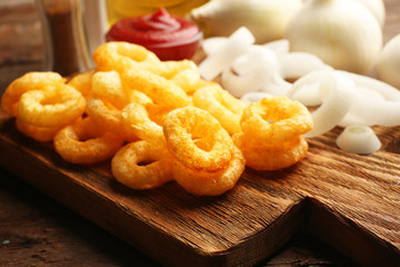 Chips rings with sauce and onion on cutting board