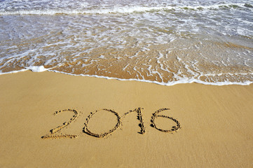 2016 written on sand beach - happy new year concept