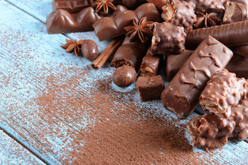 Chocolate sweets with powder on wooden background