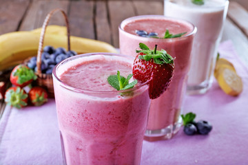 Glasses of fresh cold smoothie with fruit and berries, on the table, close-up