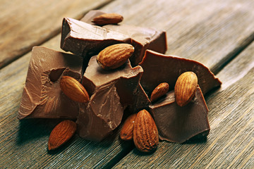 Black chocolate pieces with nuts on wooden background