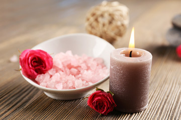 Obraz na płótnie Canvas Beautiful composition of aroma candle with pebbles and flower on wooden background