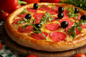 Tasty pizza with salami on decorated wooden table, close up