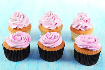 Tasty cupcakes on color wooden background