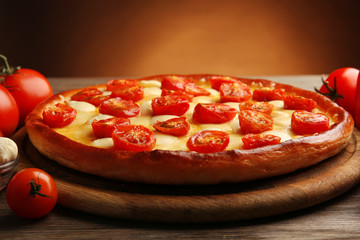 Pizza Margherita with vegetables on brown background