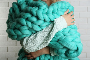 Woman wrapped in large knitted blanket