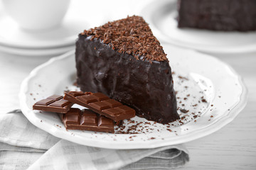 Chocolate cake with chocolate cream on plate, on light background