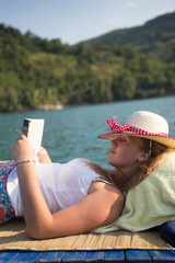 Fototapeta premium hipster girl reading a book on the boat