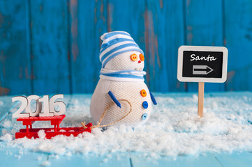 Christmas and new year concept. Handmade snowman with red sled And word 2016 near signpost With text Santa